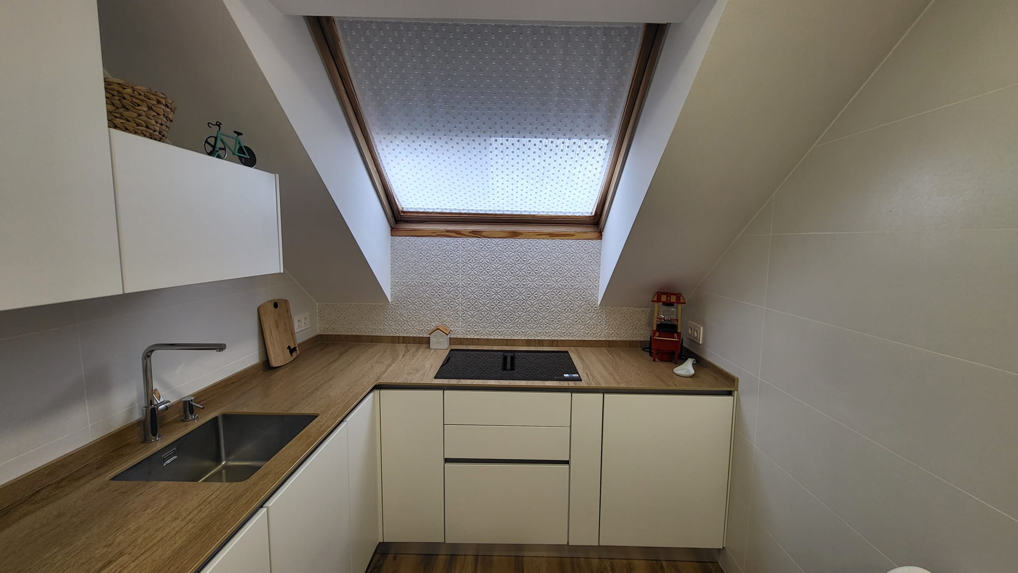 Cocina montada en un ático bajo un Velux